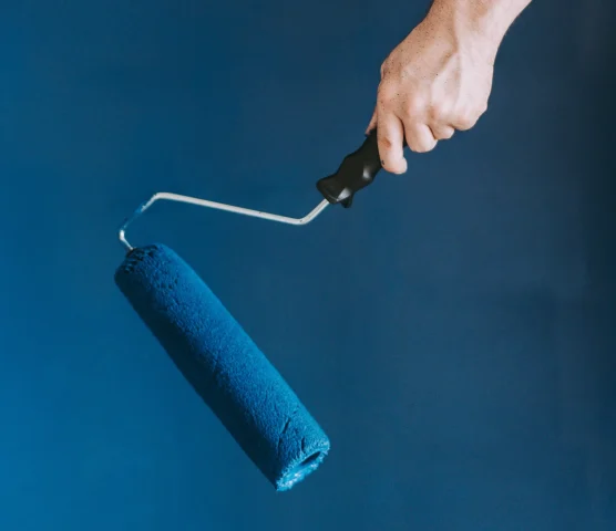 closeup-shot-female-using-paint-rollers-with-color-blue-scaled.webp